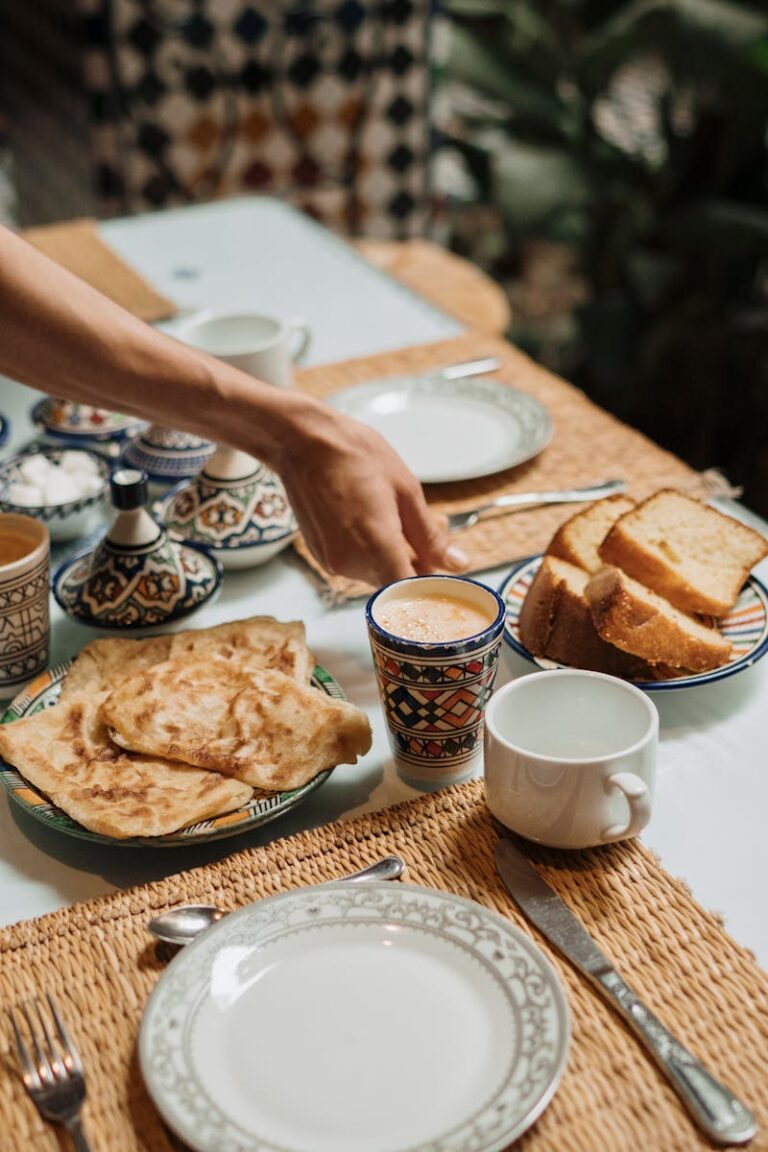 Enjoy a Moroccan breakfast setup with mint tea, crepes, and bread in a traditional setting.