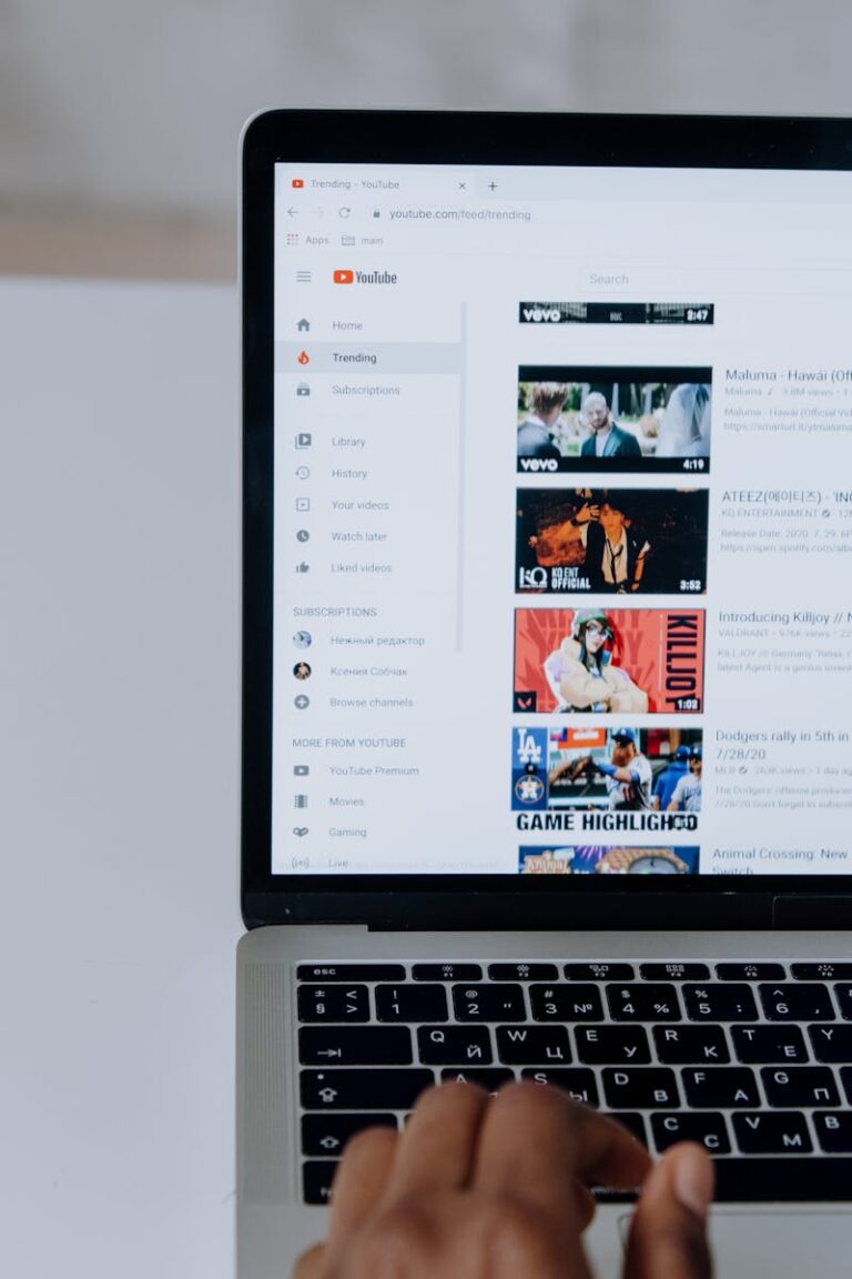 Person browsing YouTube videos on a laptop, showcasing modern technology and online content.