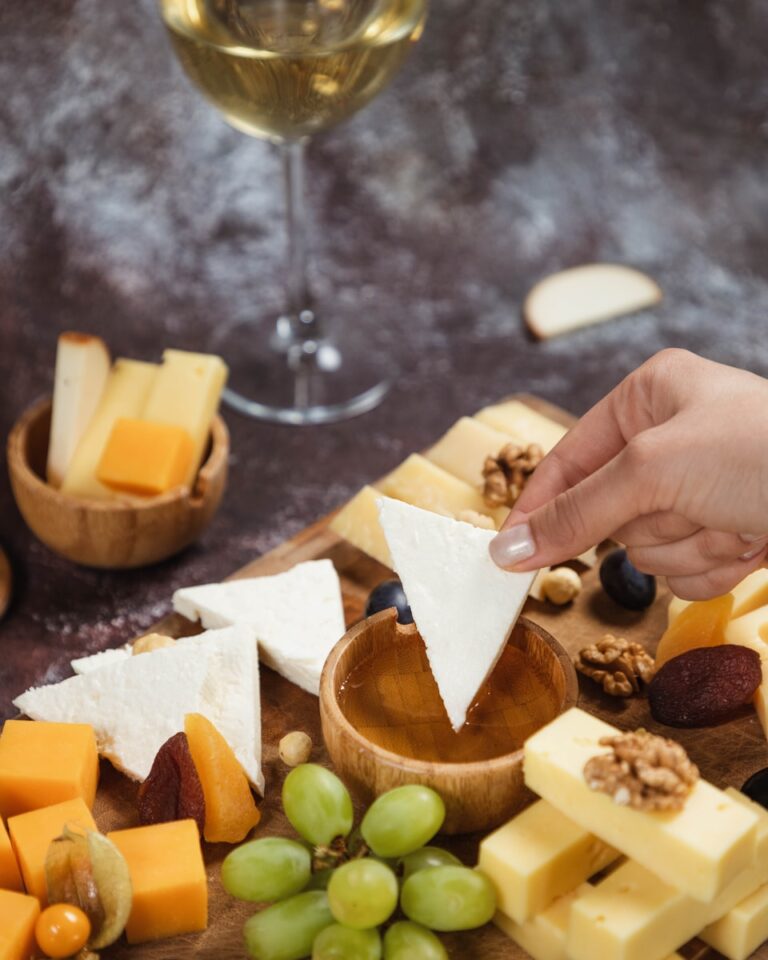 a person reaching for a piece of cheese