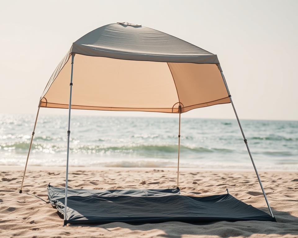 A beach tent standing firmly on the sandy shore, its fabric canopy gently billowed by the soothing ocean breeze. The slender metal frame is securely anchored, its legs sinking into the ground to provide stability against the elements. Sunlight filters through the semi-translucent material, casting a warm, inviting glow upon the serene scene. In the foreground, a neatly folded tarp lies ready to be used as a groundsheet, completing the cozy, well-equipped setup. The overall composition conveys a sense of tranquility and comfort, perfectly suited for a day of relaxation and respite by the sea.